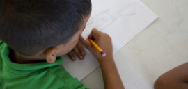 A child sits at a table drawing